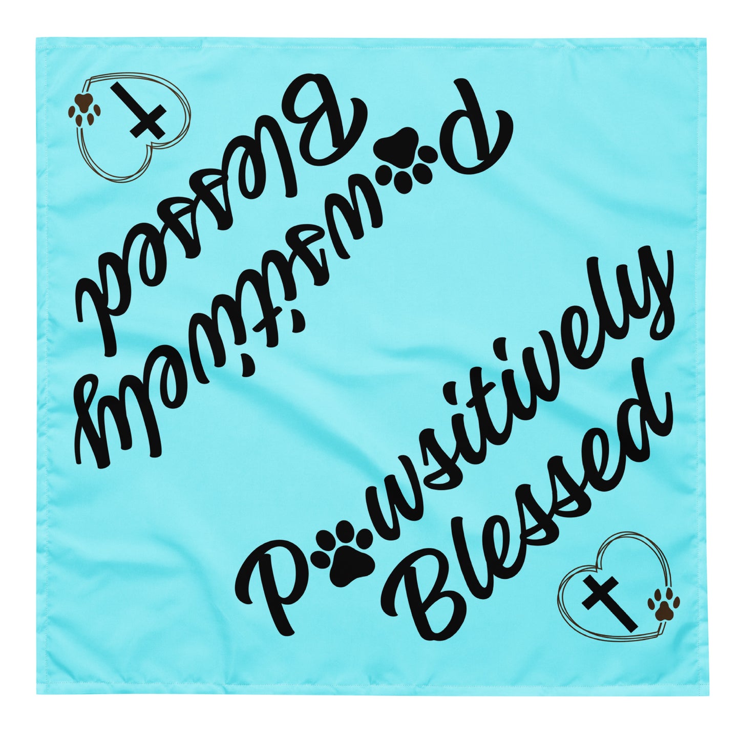 A square aqua bandana that says Pawsitively Blessed with a heart, paw prints, and cross, shown on it diagonally in two places so it can be folded in half diagonally and it will show on both sides then.