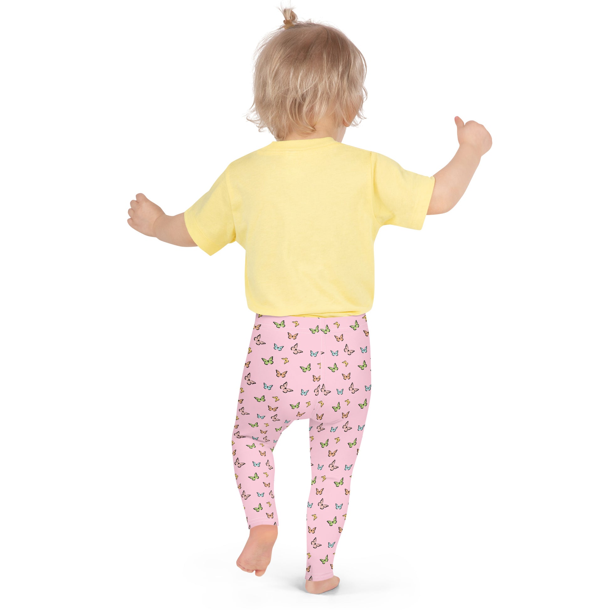 Back view of little girl in bare feet wearing yellow short-sleeved t-shirt and pink leggings with all-over butterfly print.