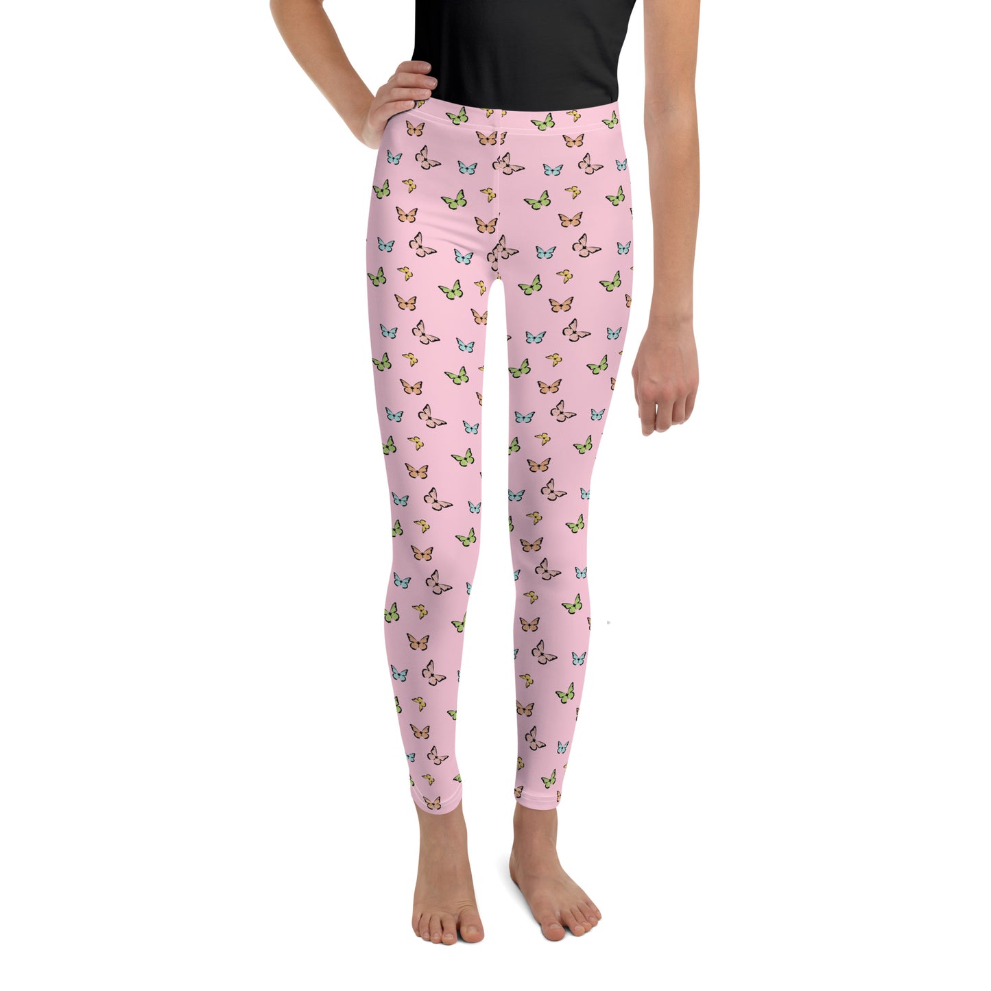 Lower half of girl with black tucked in shirt, bare feet, wearing pink leggings with pink, yellow, blue, and green butterfly print.