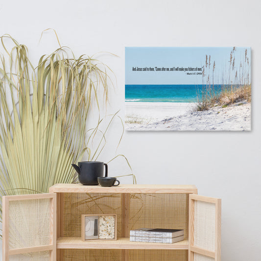 Light wood and rattan cupboard with palm leaves behind it and a picture on the wall of an ocean and beach with scripture.