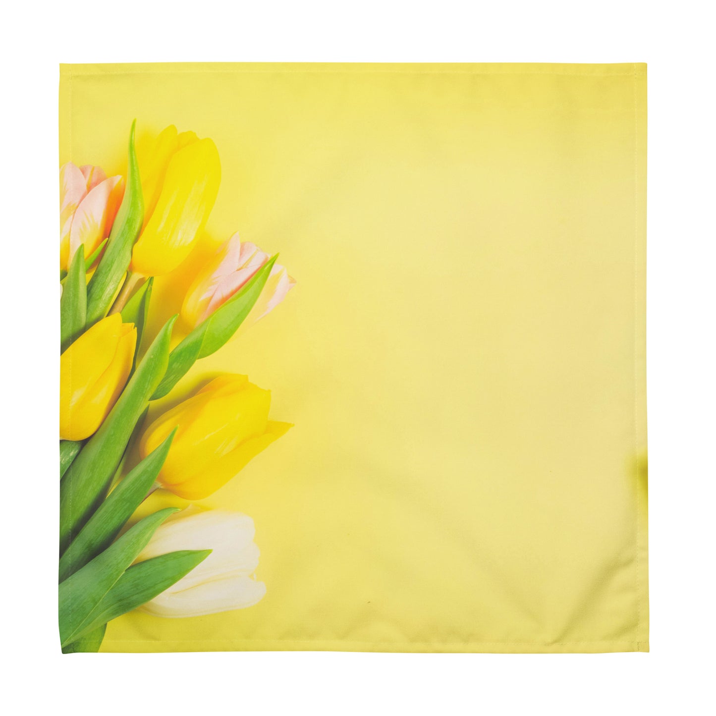 Yellow cloth napkin with white, yellow, and pink tulips on it.