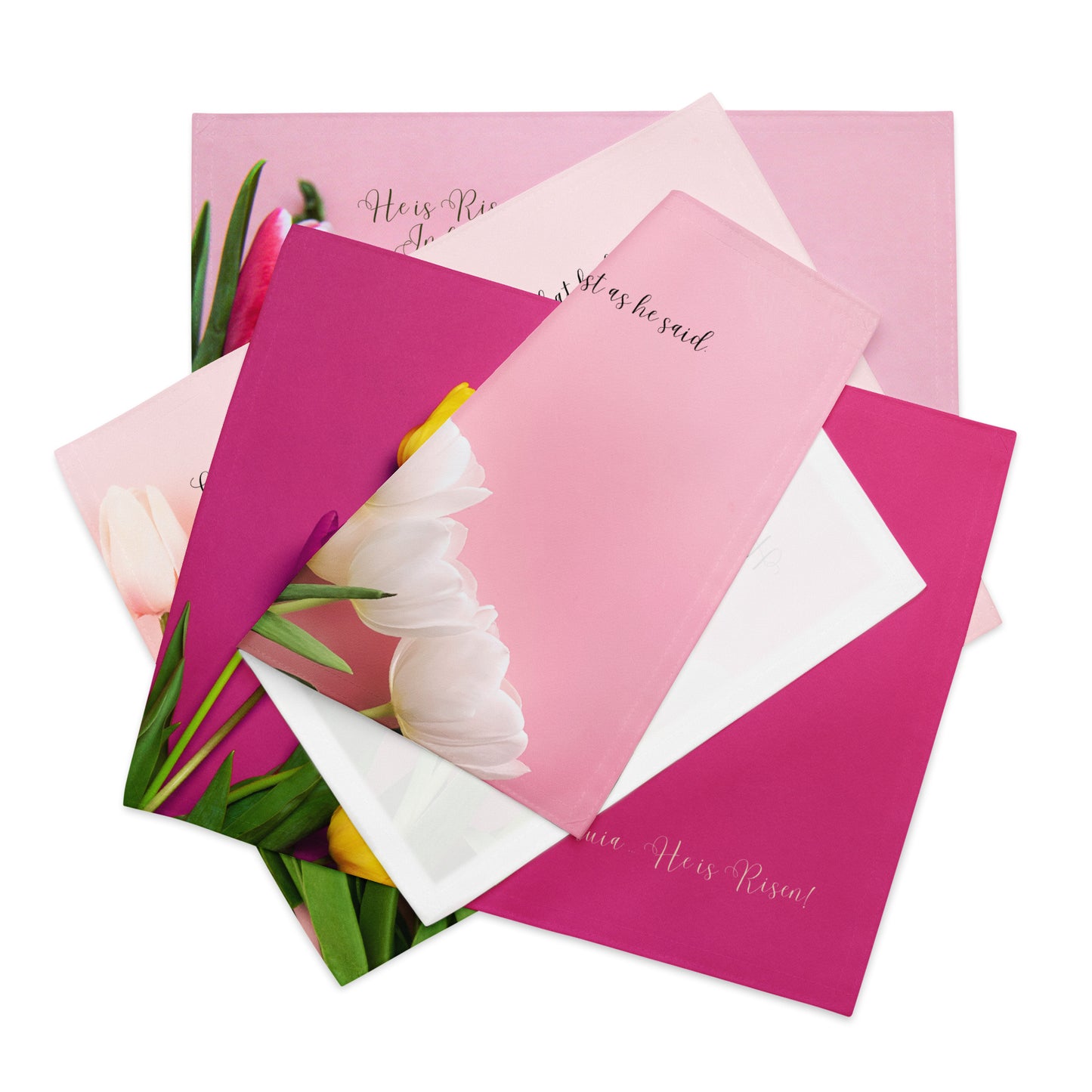 Set of four pink fabric placemats with tulips and words on them, stacked askew.