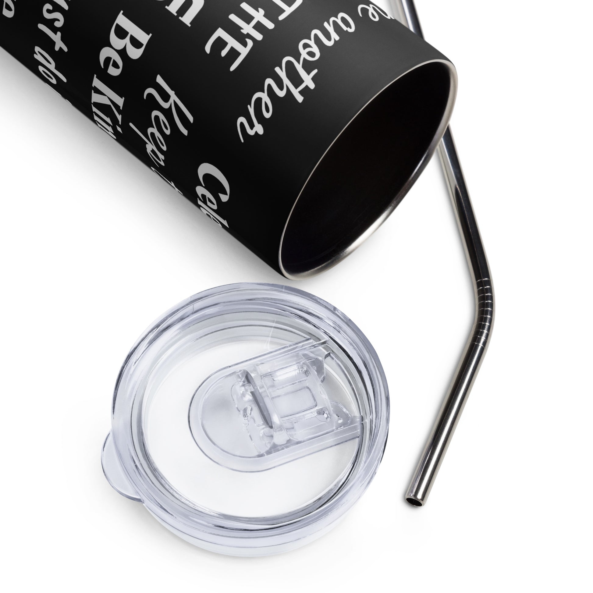 A white background and on it lies a clear lid and a long metal straw for a stainless steel tumbler with is also partially visible and lying on its side and has white words on it in different fonts.