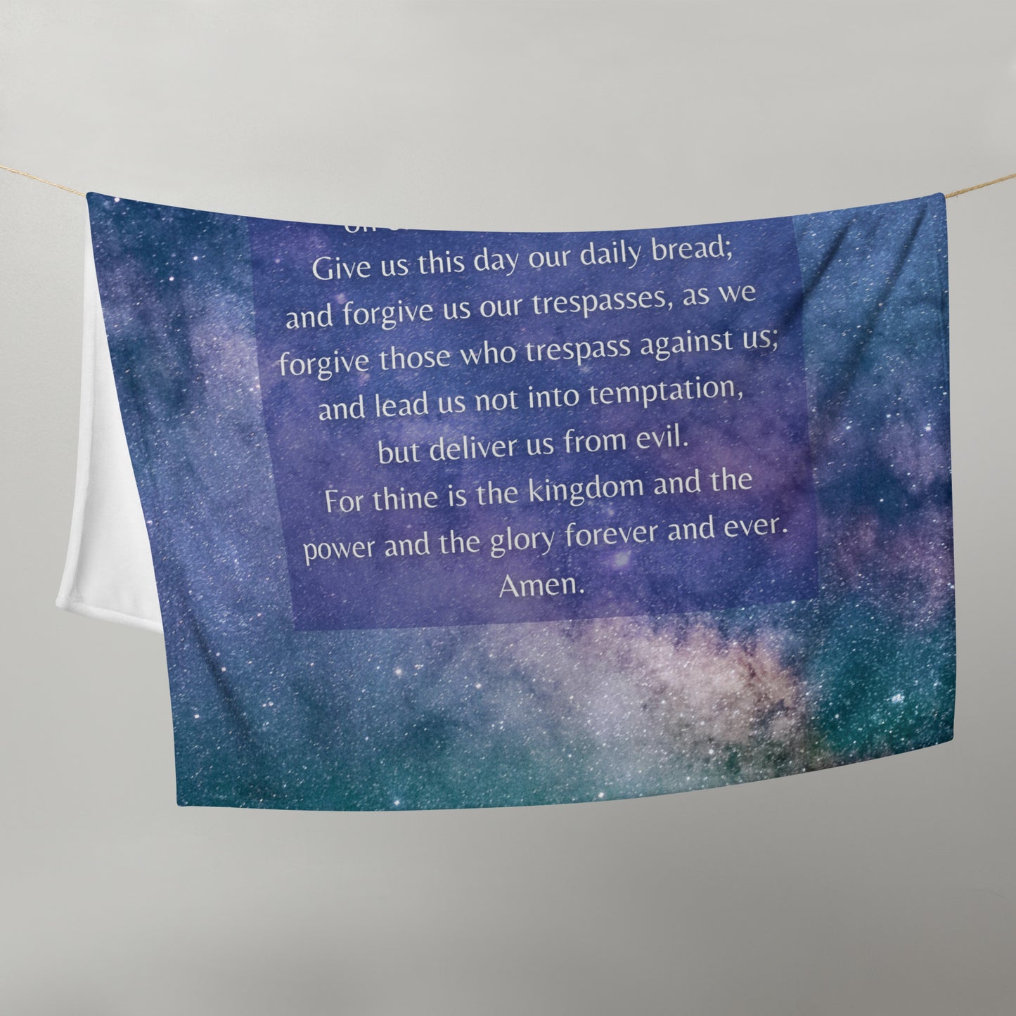 The lower half of a blue blanket with stars and part of the Lord's Prayer.