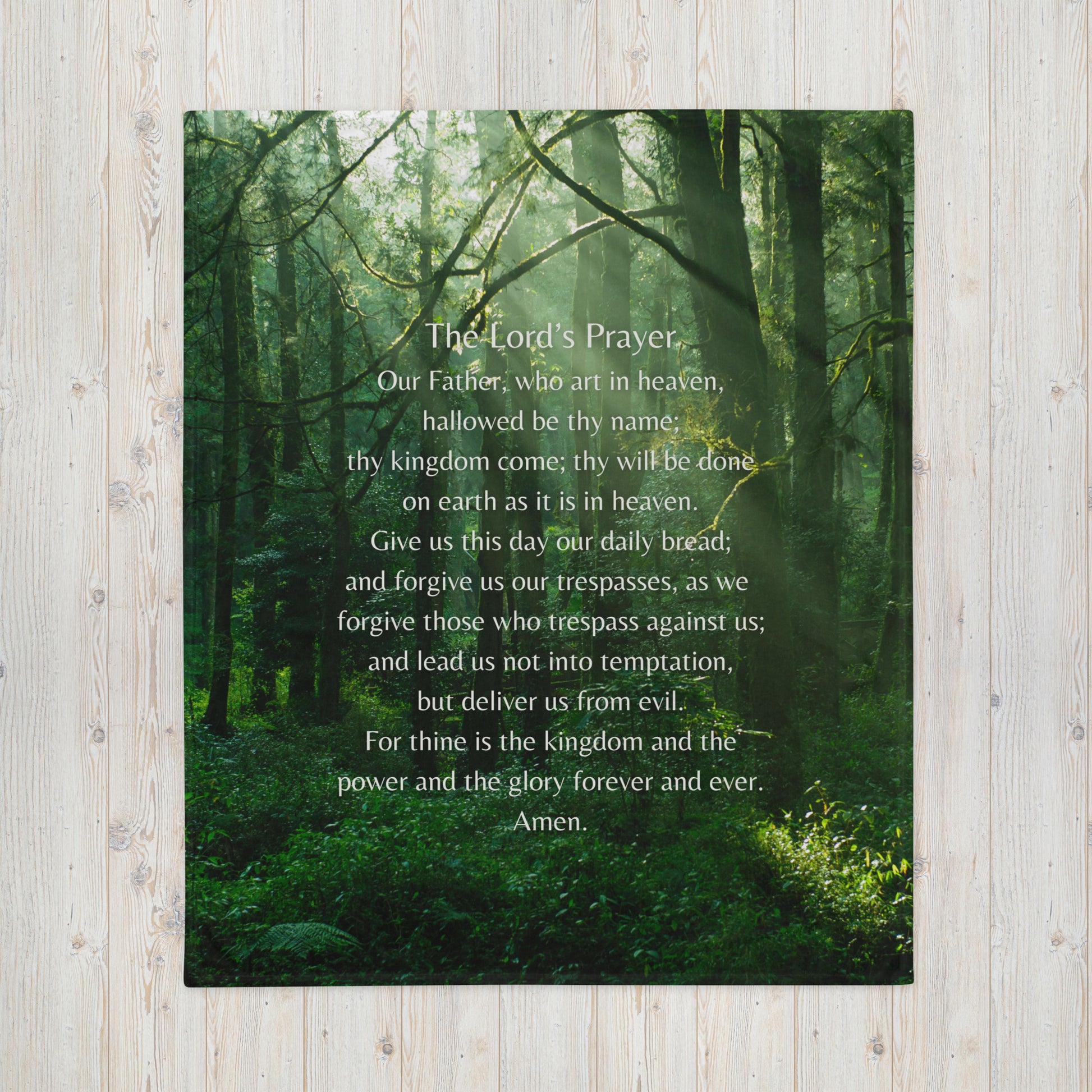 A picture of a green forest with the Lord's Prayer printed on it, printed on a throw blanket.