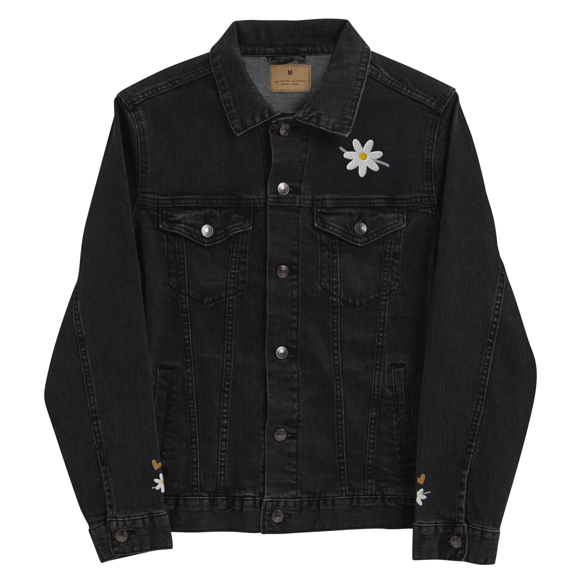 Front view of a black denim jacket with white daisy embroidered on front left lapel area and at lower part of each sleeve, along with a small gold embroidered heart on each sleeve by the daisy.