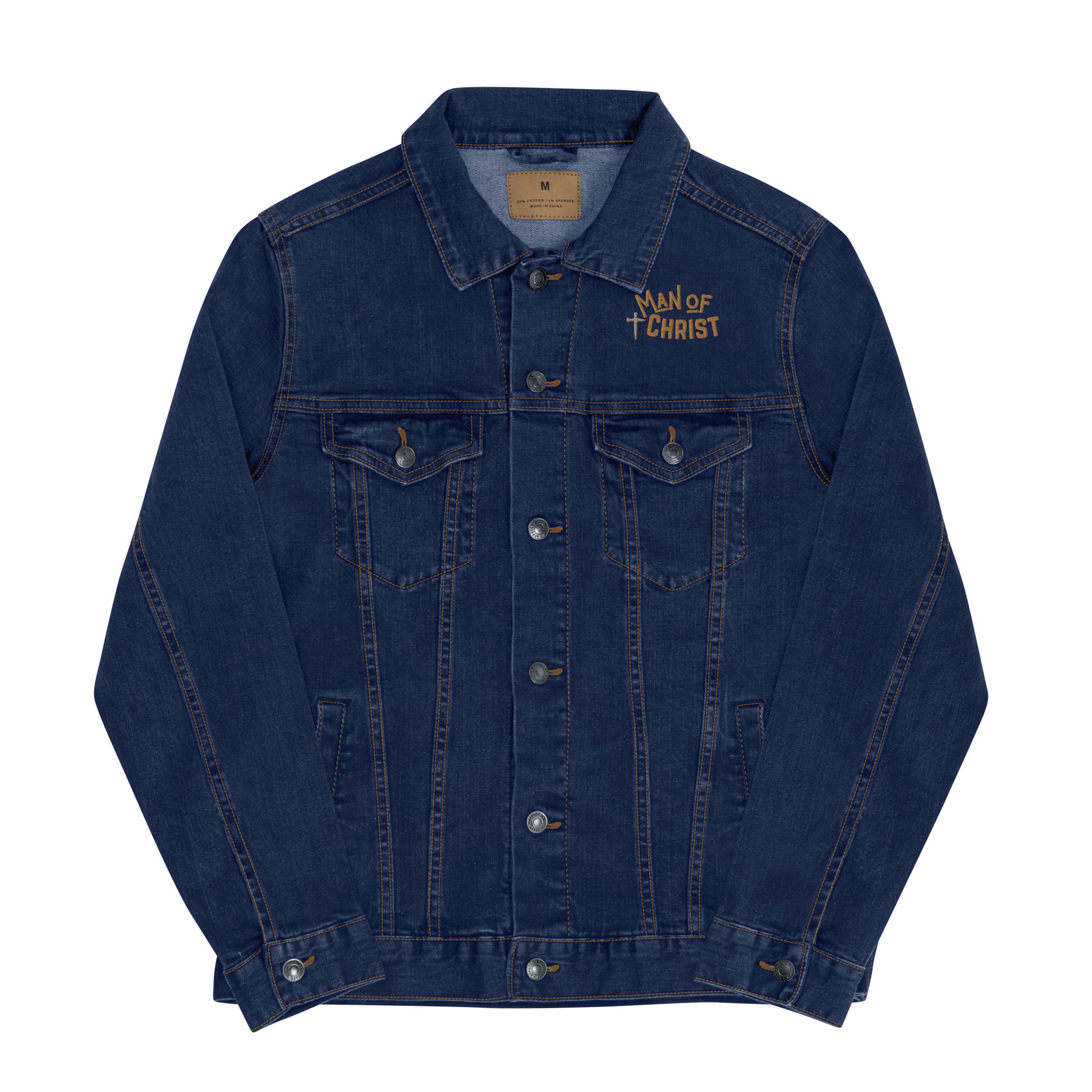 Front view of a classic blue denim jean jacket with pockets on the front and the words MAN of CHRIST embroidered above the left lapel area along with a cross.