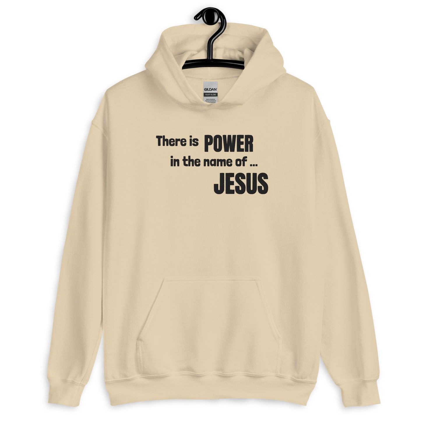 A cream colored hoodie/sweatshirt on a hanger on a hook on a white wall and the front of the sweatshirt is embroidered in dark letters to say There is POWER in the name of JESUS.