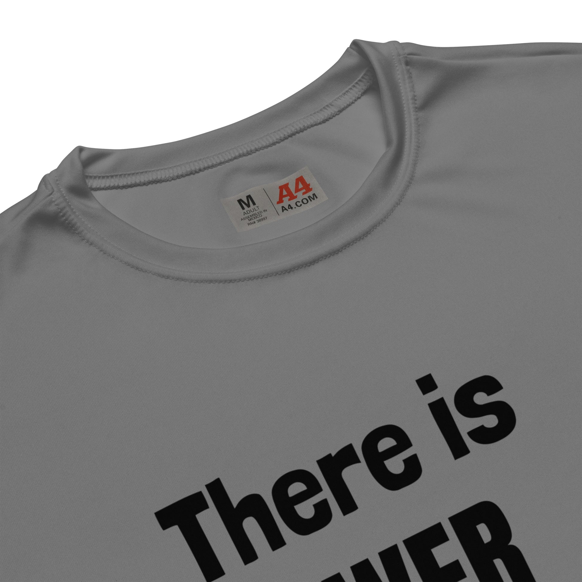 A close up view of the hemmed neckline on a gray t-shirt that shows the size tag as medium and also says A4 on the tag and you can see part of the lettering on the shirt that says:  There is.