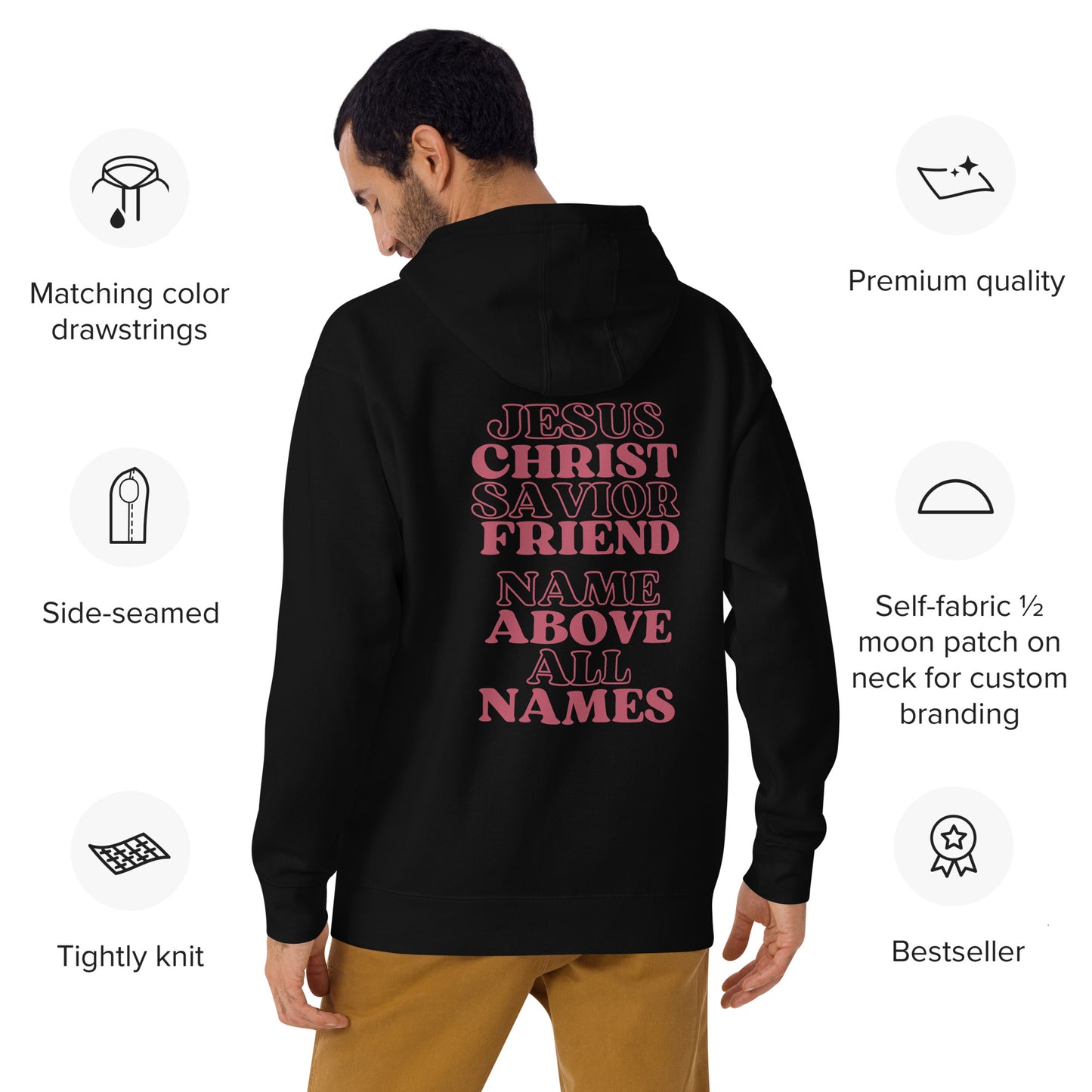 Back view of a man with dark hair in goldish brown pants is wearing a black hoodie with red-tone words on the back that says:  Jesus Christ Savior Friend Name Above All Names and on the white background around him there are small graphics with details on the features of the hoodie.