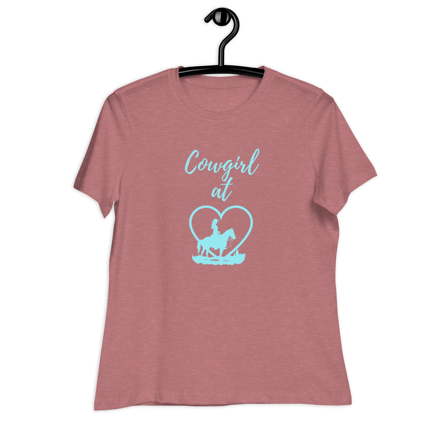 A heather mauve short-sleeved t-shirt on a black hanger with a front aqua design of a cowgirl on horseback silhouette and the words Cowgirl at and then a heart behind the cowgirl.