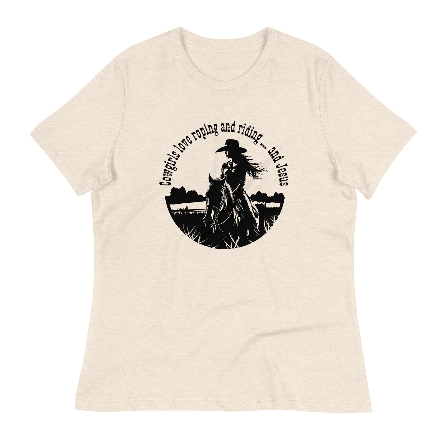 An off-white t-shirt on a really bright white background says  Cowgirls love roping and riding ... and Jesus in a circular design with an image of a long-haired girl wearing a cowboy hat riding a horse in a field.